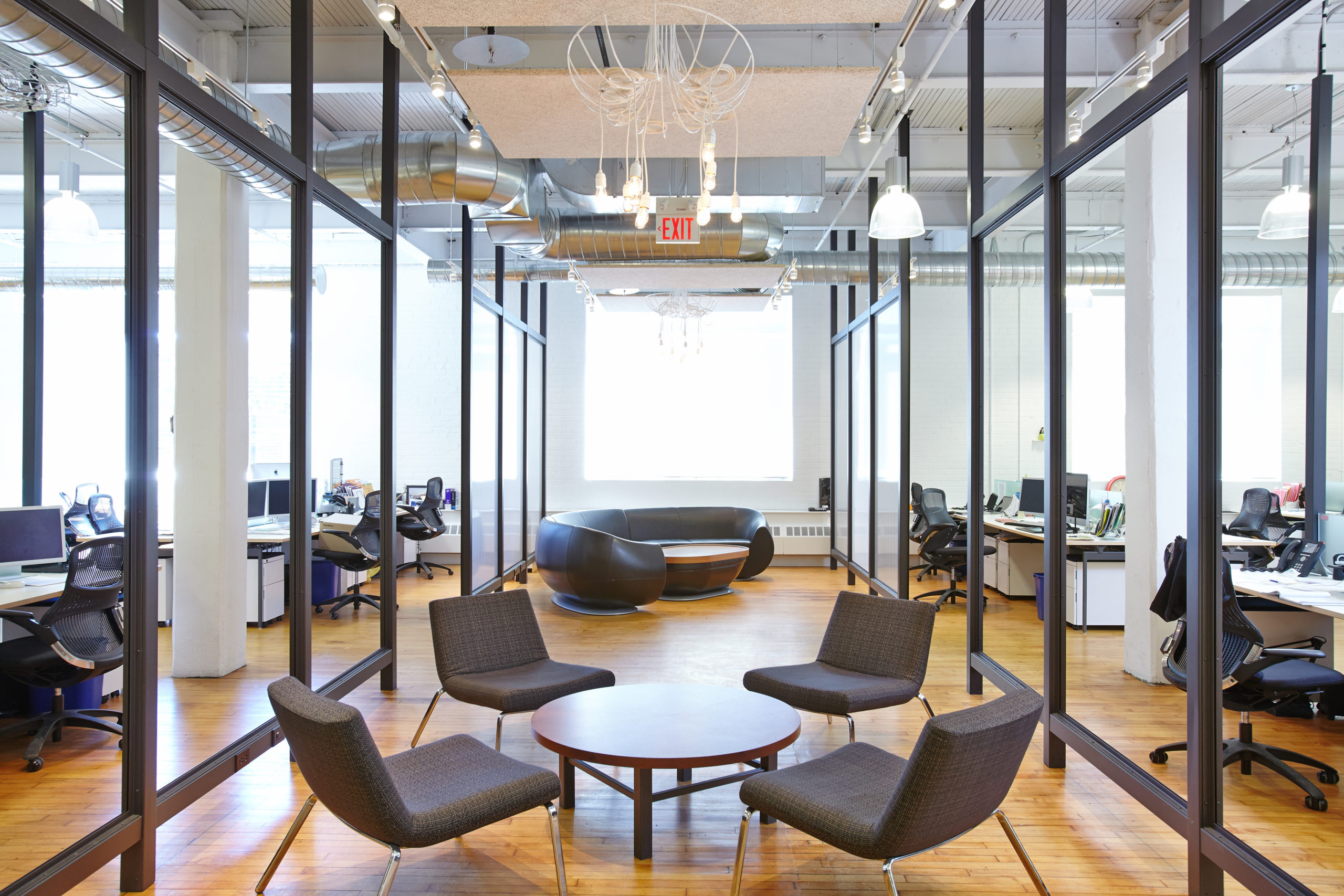 A light filled lounge with exposed brick and the building's original heritage windows